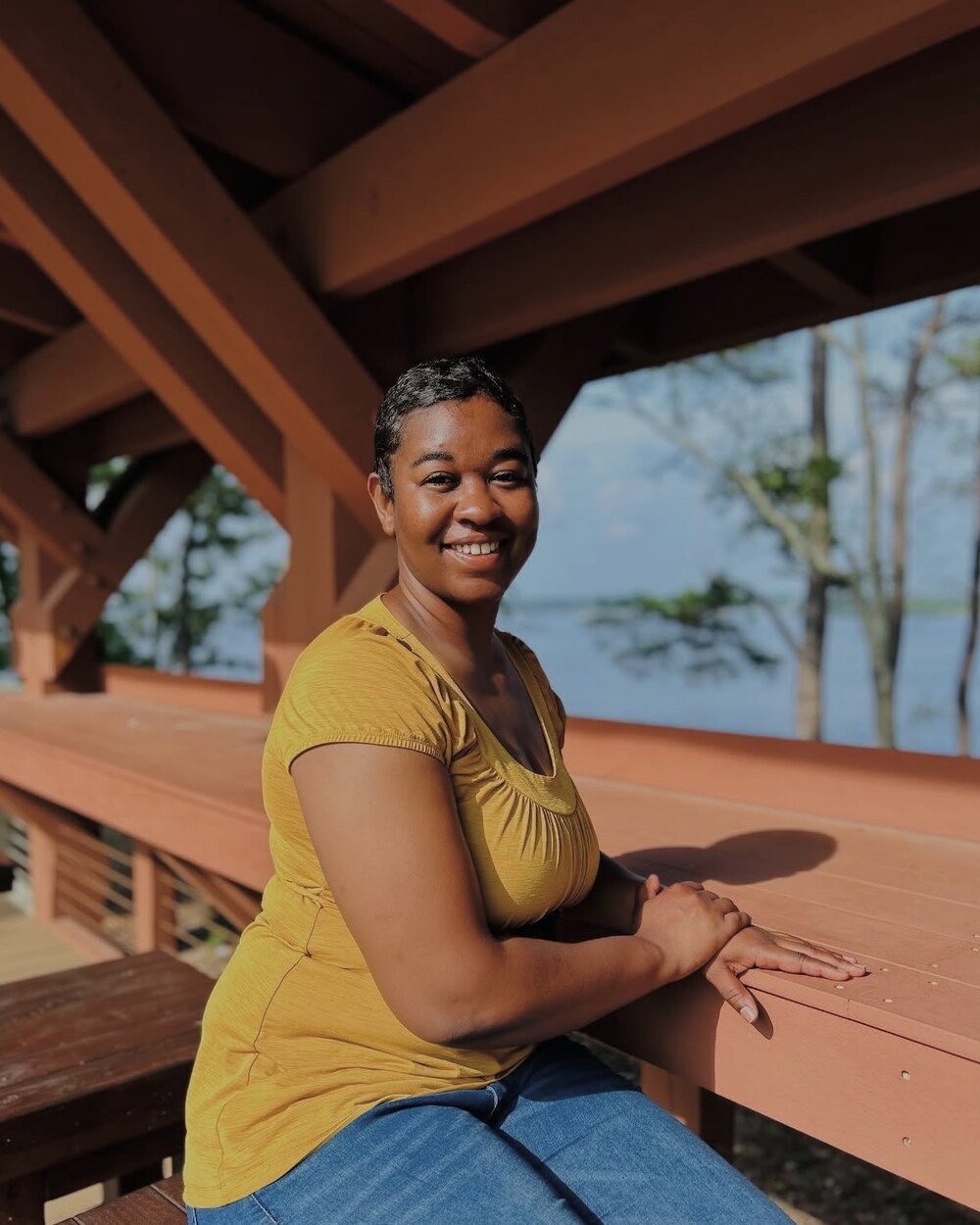 Tiffany Corey seated outdoors near the water